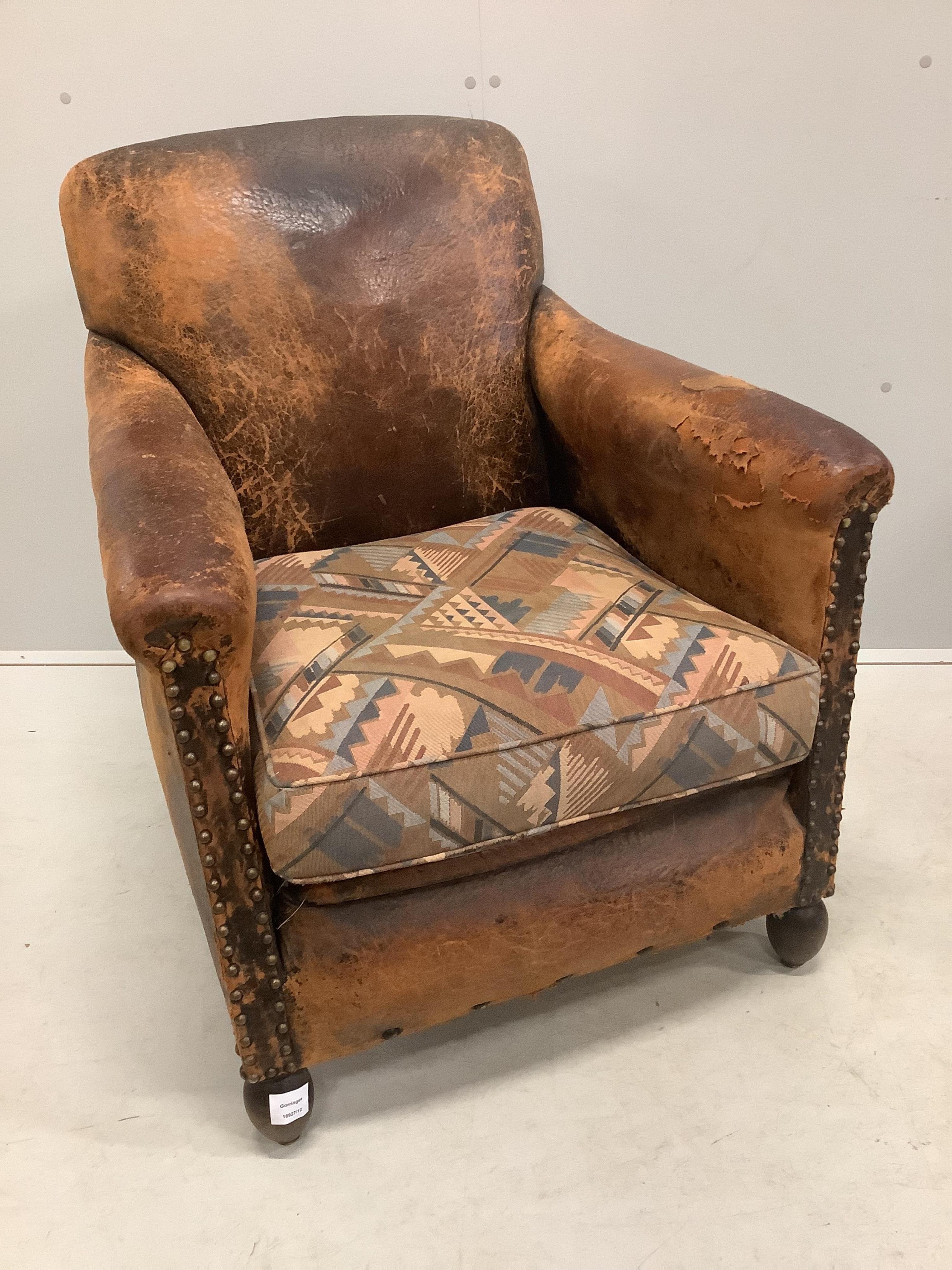 A pair of early 20th century French leather club armchairs, width 73cm, depth 74cm, height 83cm. Condition - poor to fair